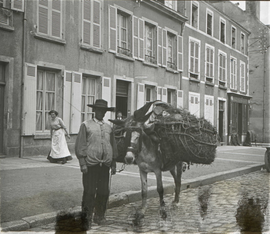 Alençon (Orne), Rue de Bretagne, transport du petit bois, personnage tenant un âne chargé [vers 1910], DR, AMA.