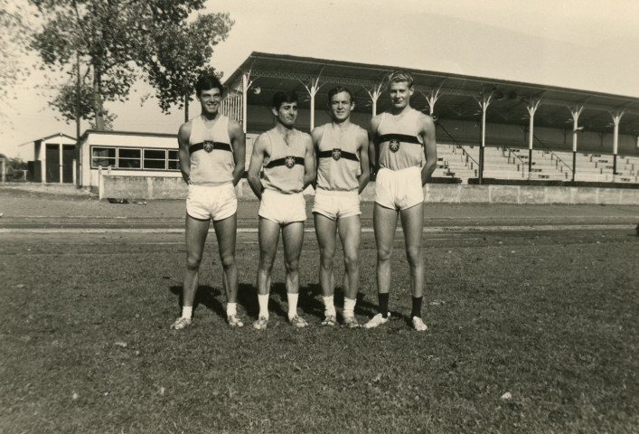 André Brilland, Caro, Michel Montgermont, Jacques Dugué, stade Jacques Fould, arrière plan : la chambre d'appel et tribunes, photographie noir et blanc, phot. Claude Varnier collection particulière Thierry Varnier, 2024, AMA.