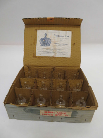 Boite de 12 ventouses en verre Epy (haut : 7cm, diam : 4.5cm), marque et modèle déposés, médaille d'argent concours Lépine 1923 (carton : 26.5 x 20 x 9).