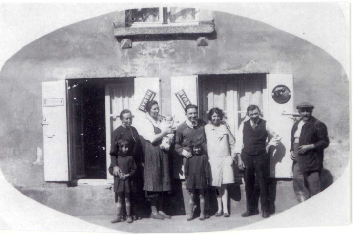 Charles, Juliette Féron, sa petite fille Denise Messager, Suzanne (fille aînée) et Léon Messager, les jumelles Charlette et Annette Féron, devant la salle du Café, photographie noir et blanc, 15.2x10, DR (1932?).
