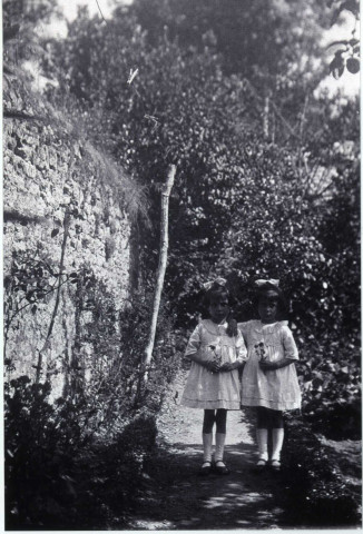 les jumelles Charlette et Annette Féron,au fond du jardin des maisons rue Cazault, à côté du noisetier, photographie noir et blanc, 10.2x15, DR.