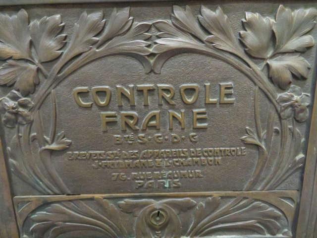 Caisse enregistreuse de magasin en bronze à décor naturaliste de fleurs et feuillages, un tiroir, deux vantaux latéraux, socle bois, avec son panonceau "Réclamez votre ticket en payant" (époque Art Nouveau) (Haut 67cm x 55cm x 43 cm).
