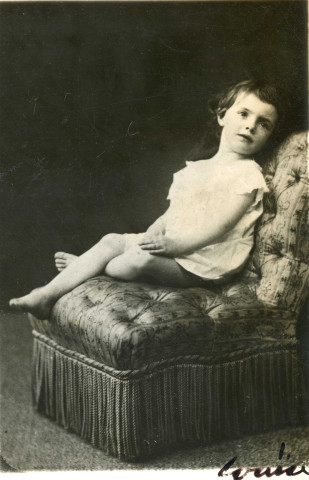 Photographie originale représentant Louise Hervieu enfant assise sur une bergère, dédicacée au dos (NB, 16,5x11,5cm), reproduite en frontispice de l'ouvrage "Montsouris".