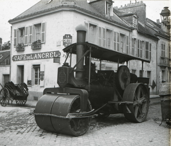 Alençon (Orne), Place de Lancrel, bitumage de la rue avec une machine à vapeur équipée d'un rouleau compresseur [vers 1910], DR, AMA.