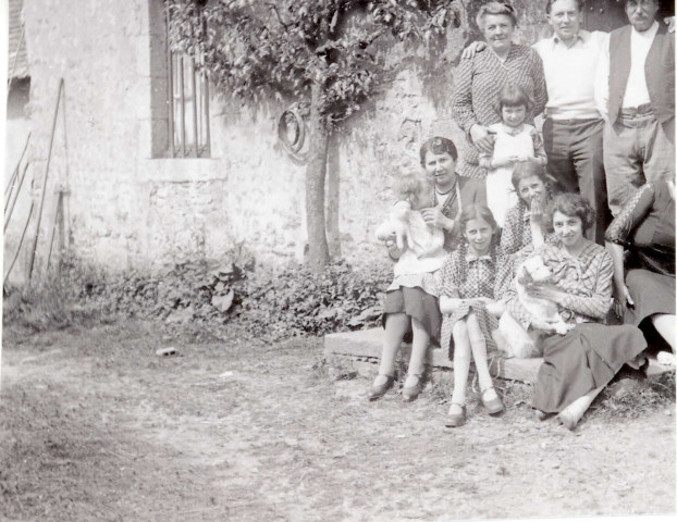 Huguette Messager sur les genoux de Juliette Féron, Léon, Denise Méssagers, les jumelles Annette et Charlette Féron, Suzanne Messager : photographie noir et blanc, DR, 12.5 x 10, [1934-1935?] (collection particulière Maryvonne Thoréton, AMA, 2018.)