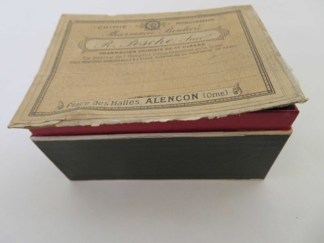 Boîte pharmaceutique rectangulaire de Raoul Pesche (couleur : blanc noir rouge) avec étiquette blanche et rose (12cm x 9cm x 7cm) (1902-1930).
