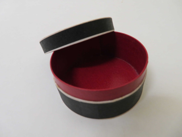 Boîtes pharmaceutiques circulaires de Raoul Pesche (couleur : blanc noir rouge) avec étiquette blanche et rose (diam : 7cm, haut : 3.2cm) (1902-1940).