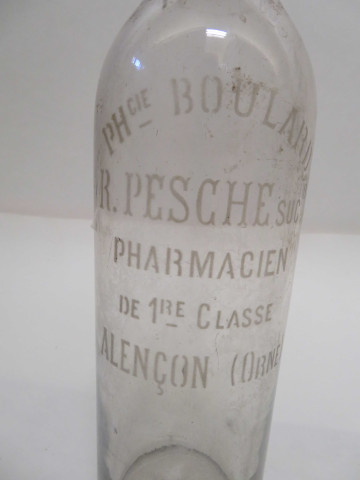 Série de 10 bouteilles en verre, couleur blanc, gravées "Pharmacie Boulard, Raoul Pesche successeur, pharmacien de première classe, Alençon Orne", bouchons émeri, en liège ou en verre (1902-1950).