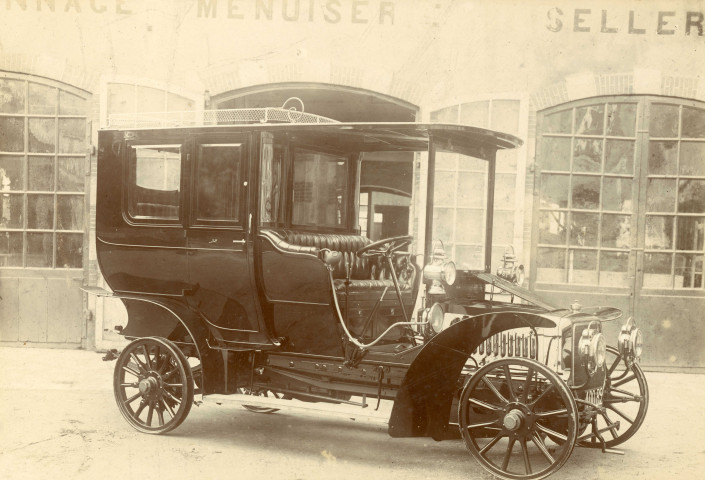 Exposition Panhard-Levassor dans la fabrique de voitures d'Albert Lemaître, voiture de maitre Panhard et Levassor (années 1908), photographie noir et blanc, (23.5cm x 18.5cm), support cartonné, collection particulière établissements Lemaître, acquisition 2022, AMA, 2 exemplaires.