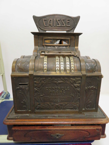 Caisse enregistreuse de magasin en bronze à décor naturaliste de fleurs et feuillages, un tiroir, deux vantaux latéraux, socle bois, avec son panonceau "Réclamez votre ticket en payant" (époque Art Nouveau) (Haut 67cm x 55cm x 43 cm).