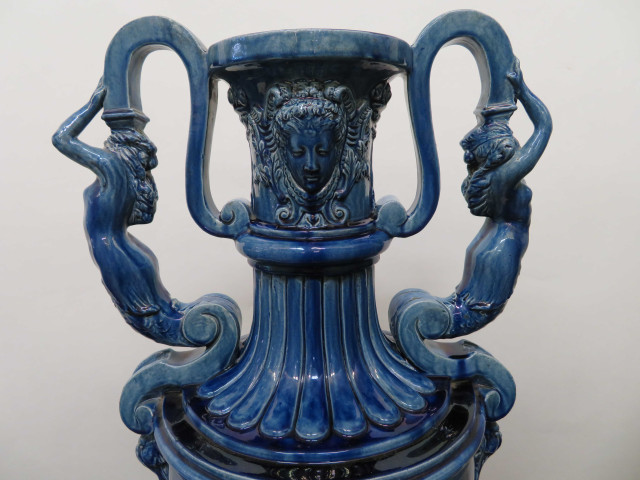Paire de vases couverts en faïence émaillé bleue, de forme amphore corps godronné, anses en sirènes, masques, sur leur base ronde à arcatures pinacles et inscriptions stylisées orientales, base bois (v1850-1860) (haut 148cm).