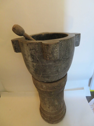 Mortier en marbre gris moucheté et veiné avec son pilon en bois, sur une base ronde en bois (XIXe siècle) (haut 91cm, diam 50cm, socle en bois 61cm).
