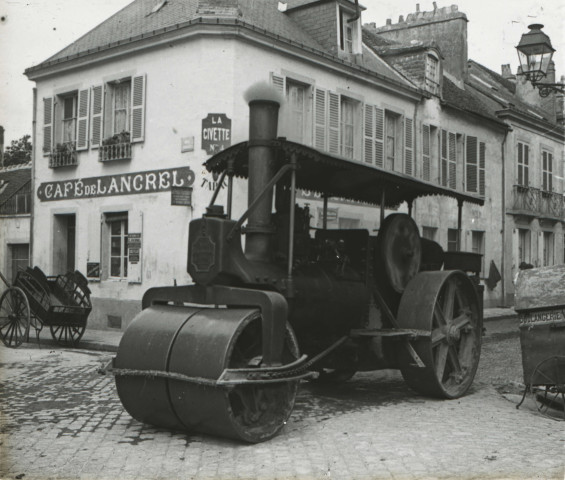Alençon (Orne), Place de Lancrel, bitumage de la rue avec une machine à vapeur équipée d'un rouleau compresseur [vers 1910], DR, AMA.