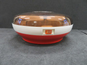 Yaourtière type 508, de forme ronde, orange et blanche avec un couvercle en plastique transparent brun fumé. Elle est accompagnée de 5 pots ronds en verre à couvercle en plastique blanc (1970) (métal, plastique, verre),Alençon Moulinex, Poids 1,4 kg, 9 pièces, don de l'association Moulinex Jean Mantelet.