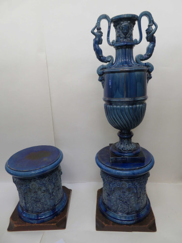 Paire de vases couverts en faïence émaillé bleue, de forme amphore corps godronné, anses en sirènes, masques, sur leur base ronde à arcatures pinacles et inscriptions stylisées orientales, base bois (v1850-1860) (haut 148cm).